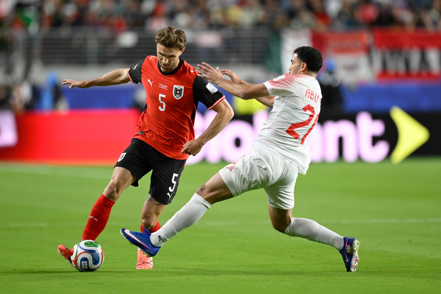 Jordan's Mohannad Abutaha (20) challenges for the ball with Austria's Stefan Posch (5) during the World Cup Group J soccer match between Austria and Jordan in Santa Clara, Calif., near San F ...