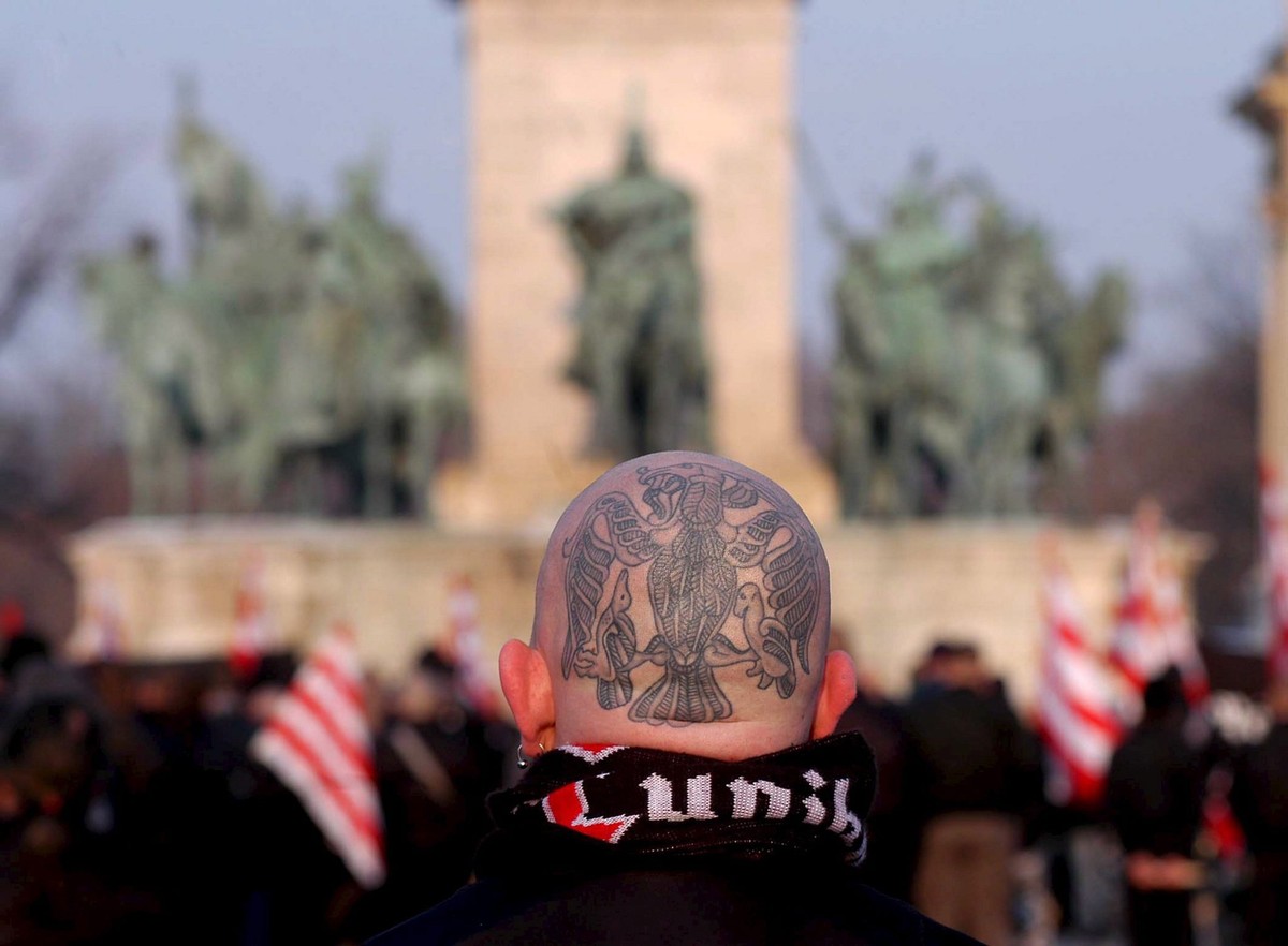Activists of the Blood and Honour Cultural Association hold far right flags on the Heroes' Square in Budapest Saturday, 11 February 2006, as more than six hundred people commemorate the 61st anni ...