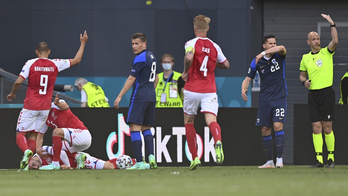 Referee Anthony Taylor, right, calls for medics to enter the field after Denmark's Christian Eriksen collapsed on the pitch during the Euro 2020 soccer championship group B match between Denmark  ...