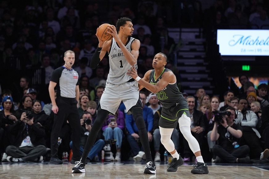 San Antonio Spurs forward Victor Wembanyama (1) handles the ball as Minnesota Timberwolves guard Jaylen Clark (22) defends during the second half of an NBA basketball game, Sunday, Jan. 11, 2026, in M ...