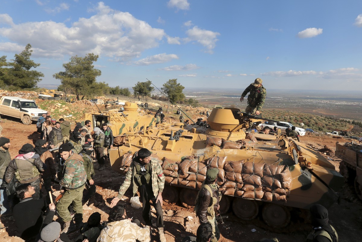 FILE - This Jan. 28, 2018 file photo, Turkish troops and pro-Turkey Syrian fighters try to take control of Bursayah hill, which separates the Kurdish-held enclave of Afrin from the Turkey-controlled t ...