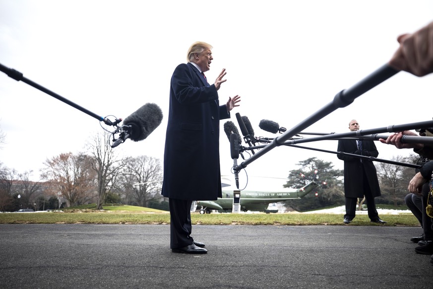 epa07300336 US President Donald J. Trump (C) speaks to the media about Syria, Nancy Pelosi, and his proposed border wall as he departs the White House for Dover Air Force Base, where he will await the ...