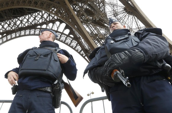 Police take up position under the Eiffel Tower the morning after a series of deadly attacks in Paris , November 14, 2015. REUTERS/Yves Herman