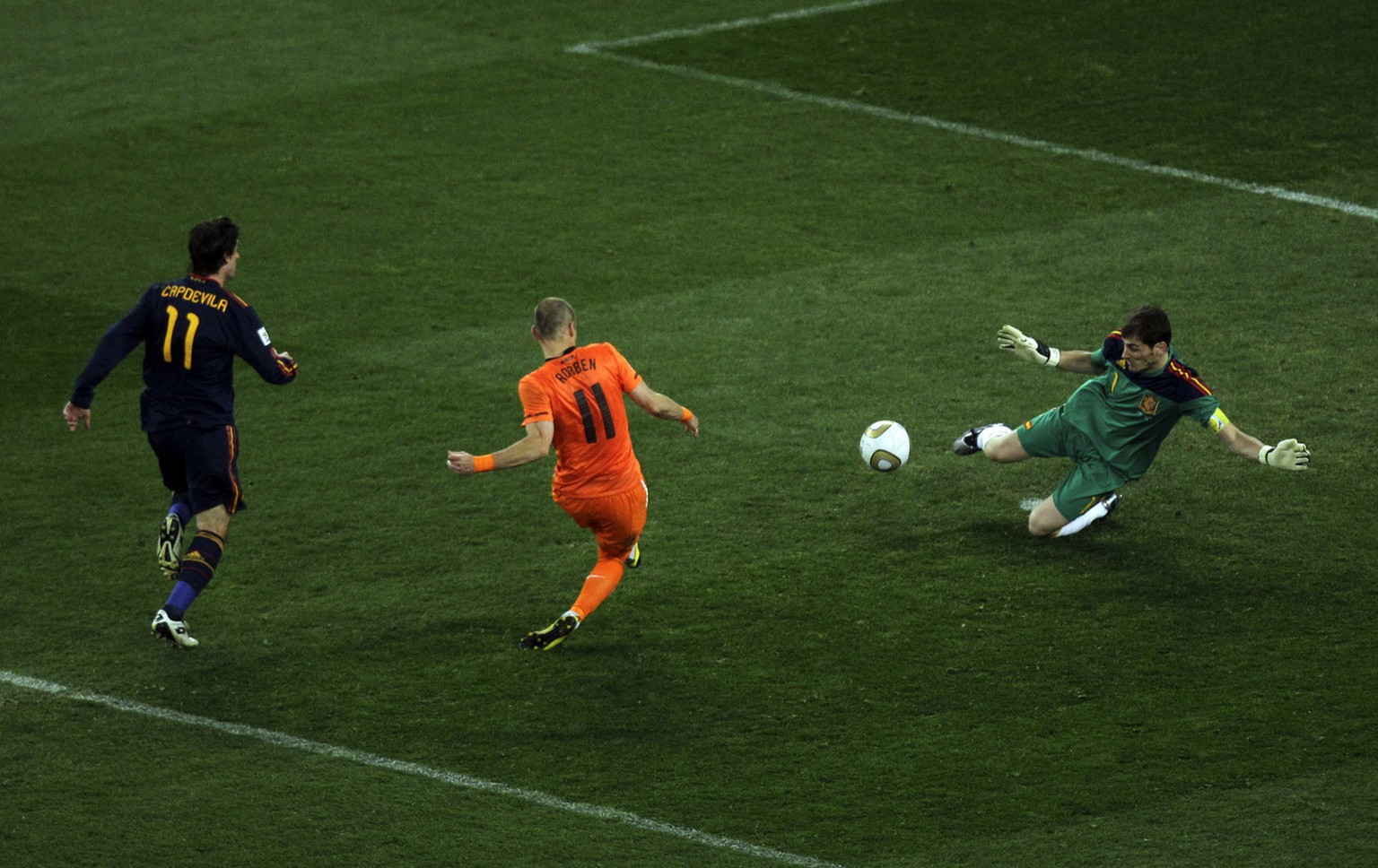 Spain goalkeeper Iker Casillas, right, deflects a shot by Netherlands&#039; Arjen Robben, center, during the World Cup final soccer match between the Netherlands and Spain at Soccer City in Johannesbu ...