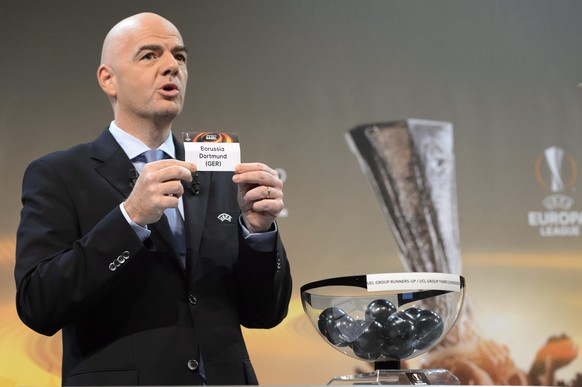 epa05068815 UEFA General Secretary and FIFA president candidate Gianni Infantino shows the lot of Borussia Dortmund during the draw of the 2015/16 UEFA Europa League Round of 32 at the UEFA Headquarte ...