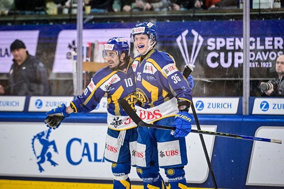 Davos` Andres Ambuehl, left, and Davos` Simon Knak celebrates after scoring during the game between Switzerland HC Davos and Finnland`s Kaerpaet Oulu, at the 96th Spengler Cup ice hockey tournament in ...