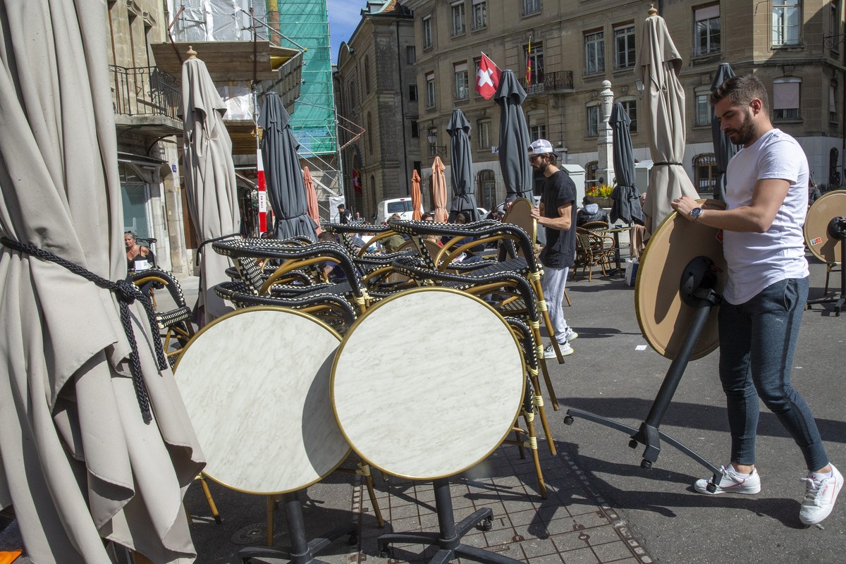 epa08297917 Employees close their restaurant 'A La Pomme d'Or' located at the Old City of Geneve, after the Geneva's authorities proclaims Monday the state of necessity to fight ag ...