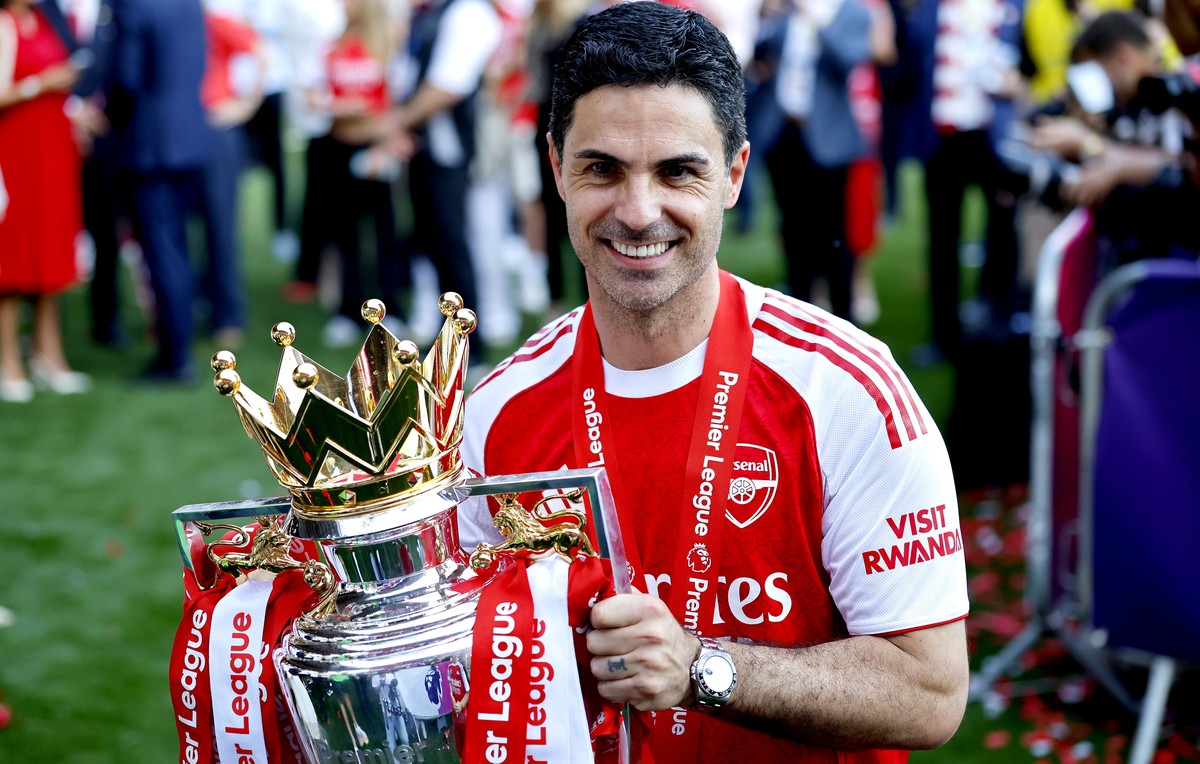 epa12991423 Arsenal manager Mikel Arteta poses with the Premier League trophy as the team celebrate the Premier League title at the end of the English Premier League match Crystal Palace against Arsen ...