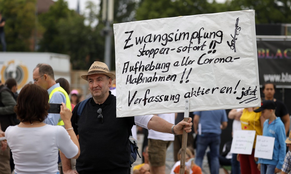 epa08412000 A man with a banner 'Stop compulsory vaccination immediately, cancel all corona measures' 'takes part in a demonstration of the initiative 'Lateral thinking' in St ...