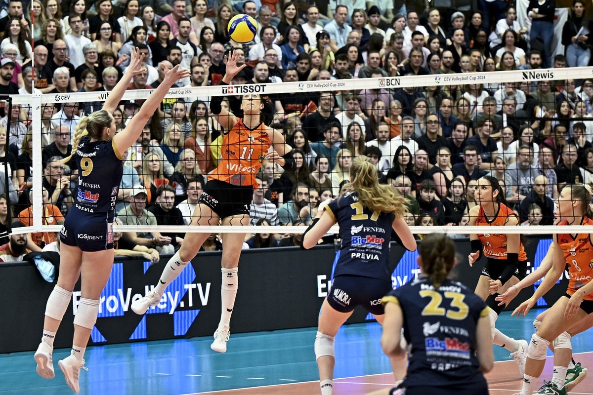 Neuchatel's volleyball player Jasmine Julianne Gross #11 spikes the ball against Chieri's volleyball player Madison Kingdon Rishel #9 Chieri's volleyball player Camilla Weitzel #17 and  ...