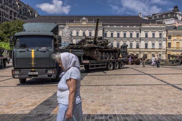 epa10095544 An elderly woman walks past a displayed Russian tank destroyed in fights with the Ukrainian army, placed on a truck trailer at Mykhailivskyi Square, on the Day of Ukrainian Statehood, in Kyiv (Kiev), Ukraine, 28 July 2022. Ukraine marked the Day of Ukrainian Statehood for the first time on 28 July 2022. Ukrainian President Zelensky approved the new public holiday last year, and parliament adopted it in May 2022. Russian troops on 24 February entered Ukrainian territory, starting a conflict that has provoked destruction and a humanitarian crisis.  EPA/ROMAN PILIPEY