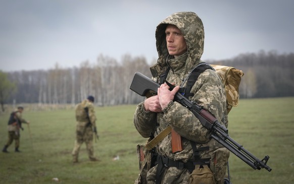 A Ukrainian soldier stands as sappers search for mines left by the Russian troops in the fields at the village of Berezivka, Ukraine, Thursday, April 21, 2022. (AP Photo/Efrem Lukatsky)