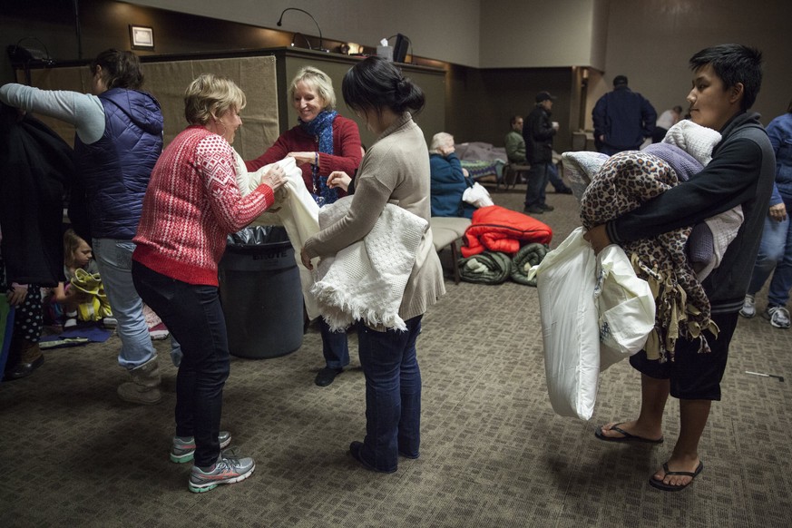 epa05790247 Volunteers help evacuees with bedding in the main sanctuary of the Neighborhood Church of Chico in Chico, California, USA, 13 February 2017. Authorities ordered mandatory evacuations of co ...