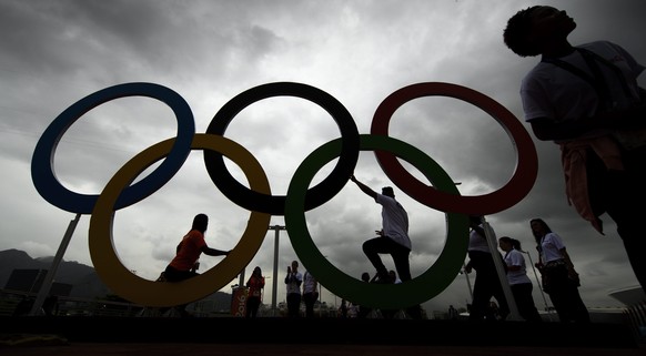 epa05453238 People pose for photos in front of Olympic Rings at the Barra Olympic Park prior to the Rio 2016 Olympic Games in Rio de Janeiro, Brazil, 02 August 2016. The Rio 2016 Olympic Games will ta ...