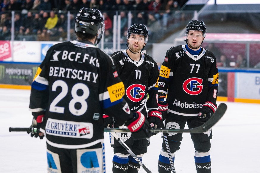 L?attaquant fribourgeois Christoph Bertschy, gauche, parle avec le defenseur fribourgeois Mauro Dufner, et le defenseur fribourgeois Maximilian Streule, droite, lors du match du championnat suisse de  ...