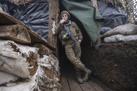 A Ukrainian soldier smokes in a trench at the line of separation from pro-Russian rebels, Donetsk region, Ukraine, Monday, Jan. 10, 2022. President Joe Biden has warned Russia&#039;s Vladimir Putin th ...