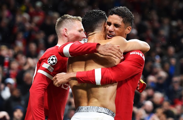 epa09496510 Cristiano Ronaldo (C) of Manchester United celebrates with teammates Raphael Varane (R) and Scott McTominay after scoring the winning goal during the UEFA Champions League group F soccer m ...