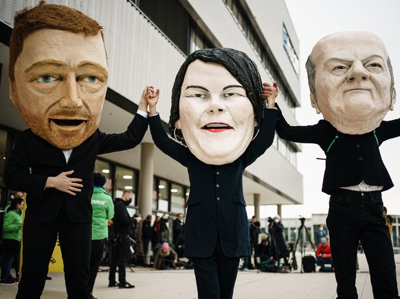 epaselect epa09518123 Activists of Campact wearing masks resembling (L-R) Free Democratic Party (FDP) chairman and faction chairman in the German parliament Bundestag Christian Lindner, Green party (D ...