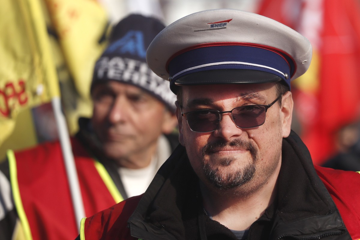 epa10440889 A man wearing a hat of France's national state-owned railway company (SNCF) takes part in a rally against the French government's planned reform of the pension system, in Montpel ...