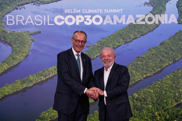Brazil President Luiz Inacio Lula da Silva, right, and Germany Chancellor Friedrich Merz join hands after meeting during the COP30 U.N. Climate Summit in Belem, Brazil, Friday, Nov. 7, 2025. (AP Photo ...
