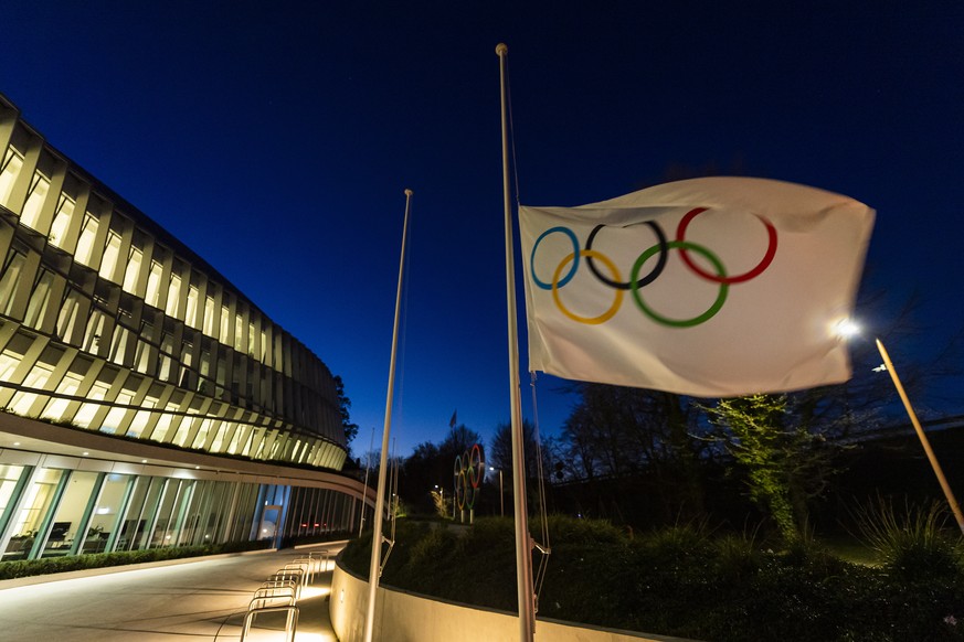 epa08316694 The Olympic flag are displayed at the entrance of the IOC, International Olympic Committee headquarters during the coronavirus disease (COVID-19) outbreak in Lausanne, Switzerland, Monday, ...