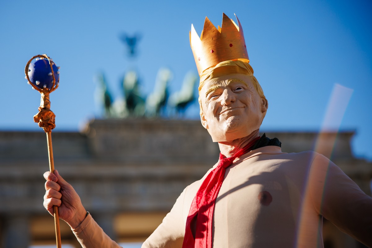 epa12462229 A person wears a costume of US President Donald J. Trump with a crown on his head during a rally in front of the Brandenburg Gate in Berlin, Germany, 18 October 2025. The rally, under the  ...