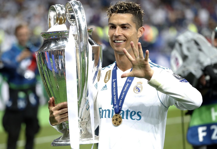 FILE - In this Saturday, May 26, 2018 file photo Real Madrid&#039;s Cristiano Ronaldo celebrates with the trophy after winning the Champions League Final soccer match between Real Madrid and Liverpool ...