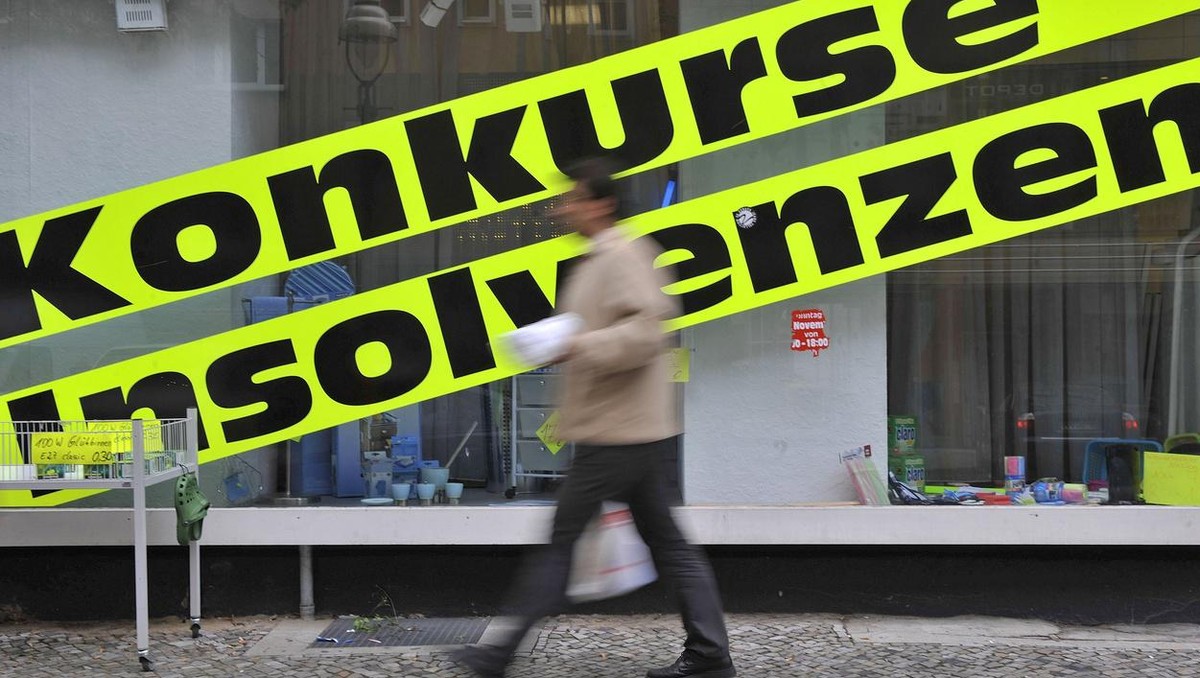 Ein Mann geht am Dienstag, 9. Juni 2009, in Berlin an einem Geschaeft mit Werbeschildern mit der Aufschrift "Konkurse, Insolvenzen", das Artikel aus Geschaeftsaufloesungen verkauft, vorbei.  ...