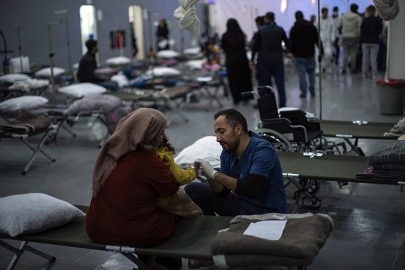 Patients affected by the earthquake are seen by medical personnel in a makeshift hospital set up at Turkish Bayraktar warship anchored in a port near Iskenderun city, southern Turkey, Tuesday, Feb. 14 ...