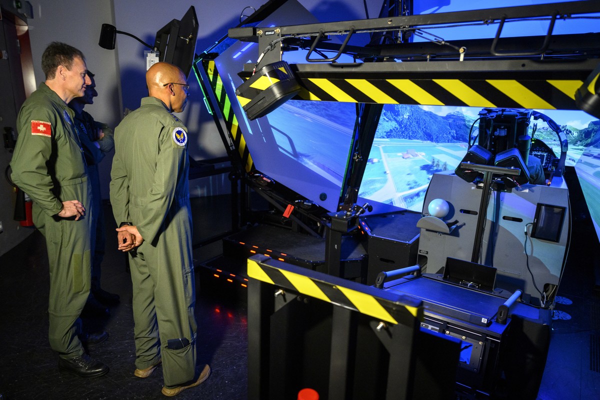 epa09826044 US's Charles Q. Brown Jr. (R), Chief of Staff of the United States Air Force and Commander of the Swiss Air Force Major General Peter Merz (L) look at a pilot of the Swiss Army who is ...