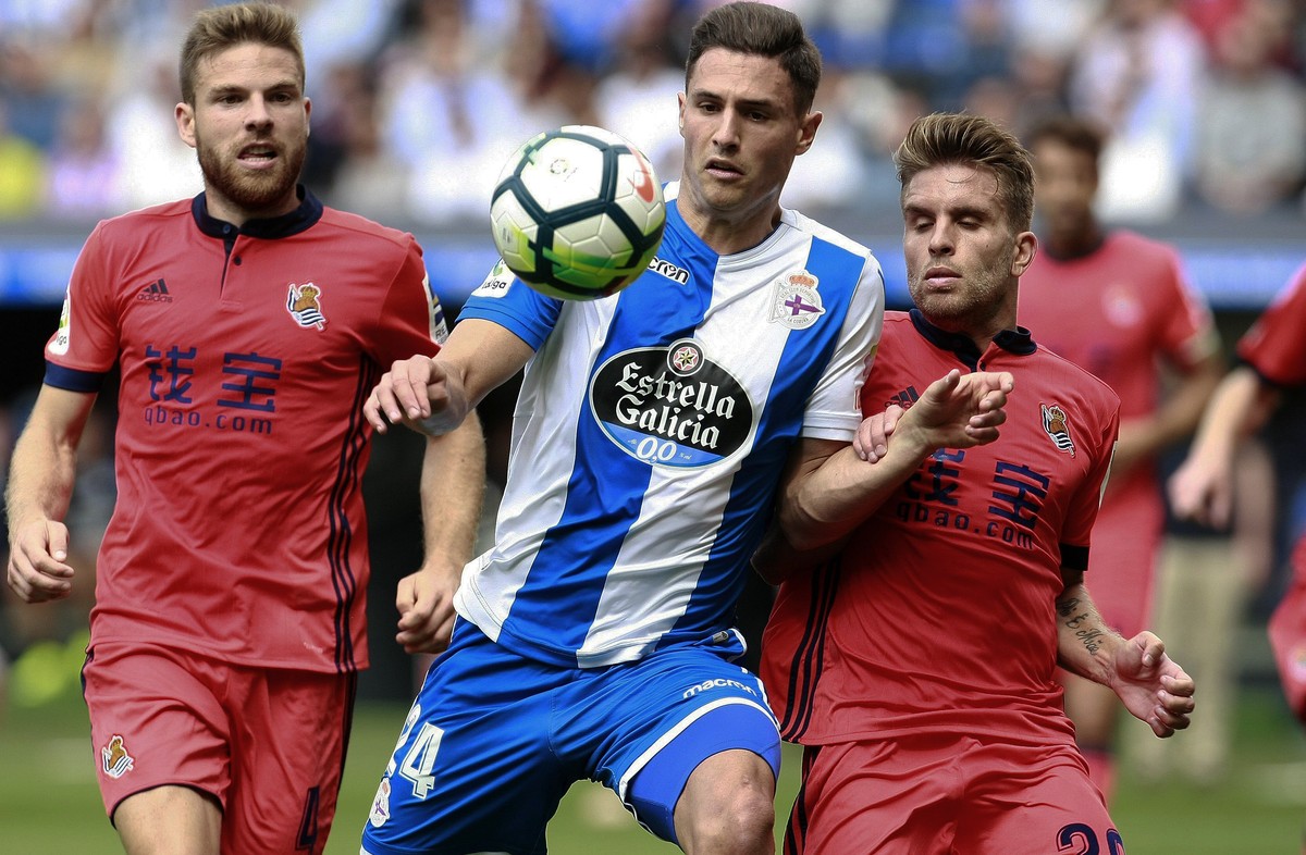 epa06195856 Deportivo Coruna's Swiss defender Fabian Schaer (C) in action against Real Sociedad's Asier Illarramendi (L) and French Kevin Rodrigues during their Spanish Primera Division Leag ...