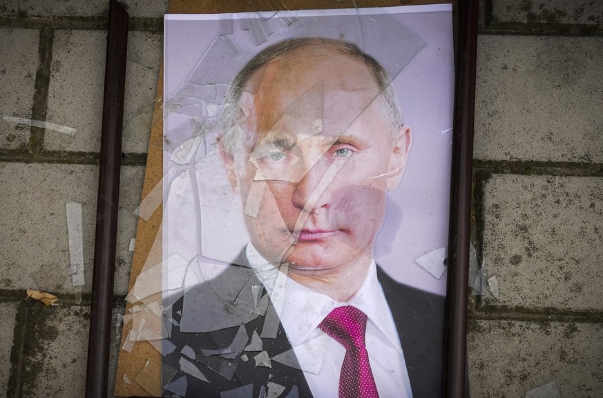 A portrait of Russian President Vladimir Putin lies on the ground near the local prison in Kherson, Ukraine, Wednesday, Nov. 16, 2022. The Russian retreat from Kherson marked a triumphant milestone in ...