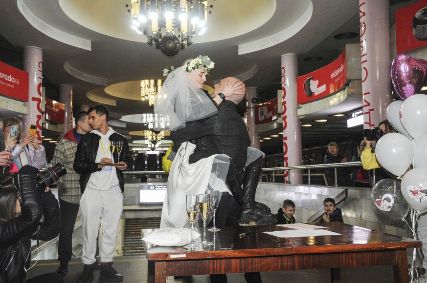 Volunteers Anastasia, center left, and Anton attend their wedding ceremony at the Universytet (University) metro station in Kharkiv, Ukraine, Sunday, April 3, 2022. (AP Photo/Andrew Marienko)