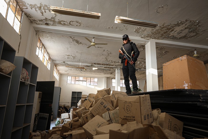 epaselect epa11801620 A Syrian rebel fighter stands on boxes as they search for captagon pills, a synthetic amphetamine-type stimulant, at a site where the drug was produced, in Damascus, Syria, 01 Ja ...