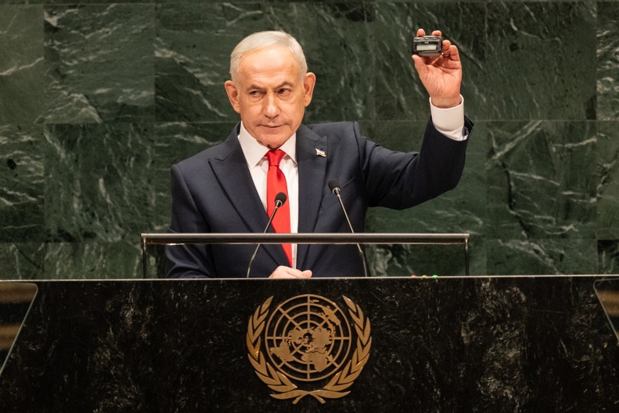 KEYPIX - epa13260993 Israel's Prime Minister Benjamin Netanyahu holds a pager similar to what were altered by Israeli intelligence to eliminate many Hezbollah fighters as a reminder of Israel cap ...