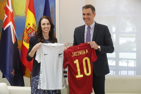 epa10037872 Spanish Prime Minister, Pedro Sanchez (R), and his New Zealand&#039;s counterpart, Jacinta Ardern (L), hold jerseys of their National Soccer Teams shortly before they exchange them as a pr ...