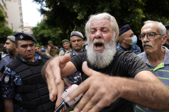 A man shouts as he protests against banks outside a bank where another armed man holds hostages in Beirut, Lebanon, Thursday, Aug. 11, 2022. A Lebanese security official says a man armed with a shotgu ...