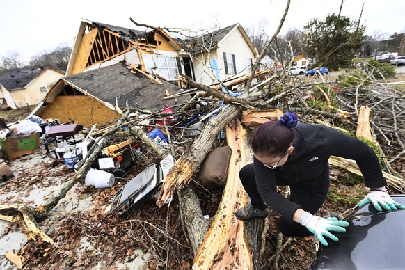 A resident climbs over debris after her friend&#039;s home was lifted off its foundation on Sunday, Dec. 10, 2023, Clarksville, Tenn. Tornados caused catastrophic damage in Middle Tennessee Saturday a ...