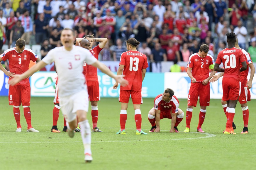 Swiss soccer players are desapointed as PolandÕs defender Artur Jedrzejczyk, left, celebrates during the UEFA EURO 2016 round of 16 soccer match between Switzerland and Poland, at the Geoffroy Guichar ...