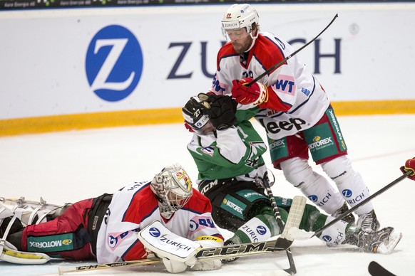 Biels Torhueter Elien Paupe, links, und Biels Beat Forster, rechts, im Spiel gegen Oltens Devin Muller, Mitte, beim Swiss Ice Hockey Cup 1/8 Final zwischen dem EHC Olten und dem EHC Biel-Bienne am Son ...