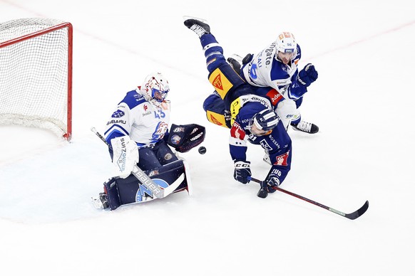 Zugs Anton Lander, Mitte, kaempft um den Puck mit Zuerichs goalkeeper Jakub Kovar, links, und Maxim Noreau, rechts, im ersten Eishockey Playoff-Finalspiel der National League zwischen dem EV Zug und d ...