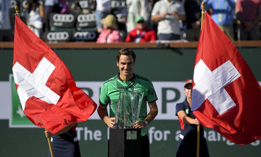 Roger Federer, of Switzerland, poses with the trophy after his win against Stanislas Wawrinka, of Switzerland, in the finals of the BNP Paribas Open tennis tournament, Sunday, March 19, 2017, in India ...
