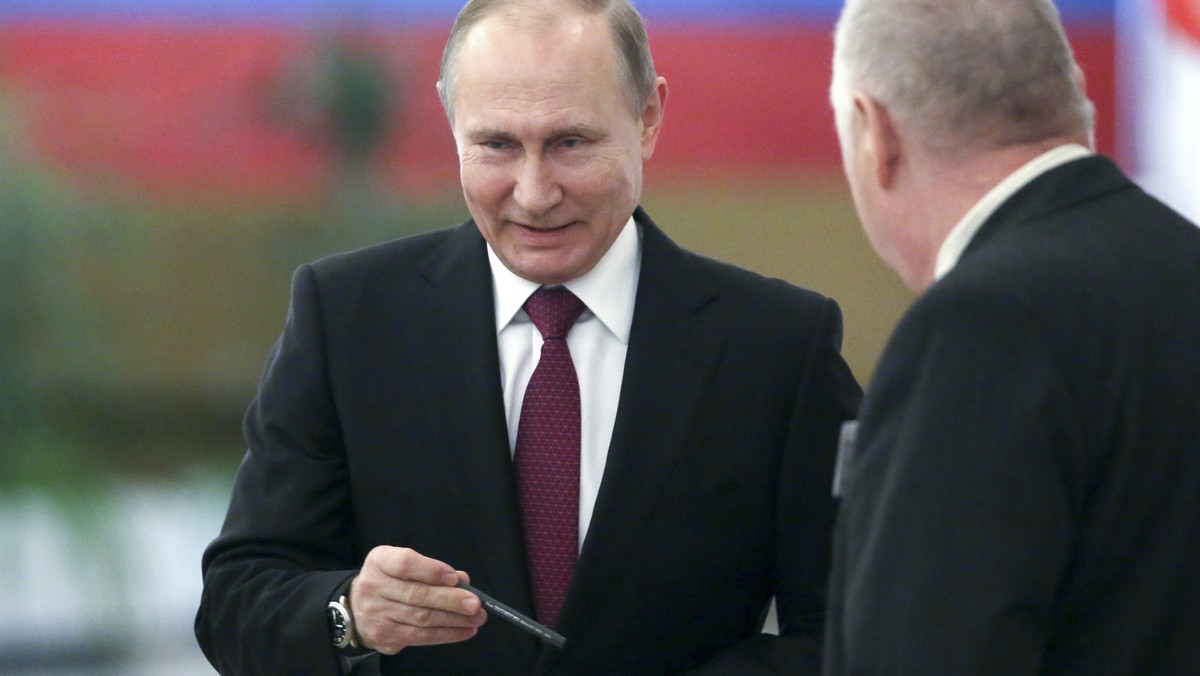 Russian President and Presidential candidate Vladimir Putin, center, prepares to cast his ballot during Russia's presidential election in Moscow, Russia, Sunday, March 18, 2018. Putin's vict ...