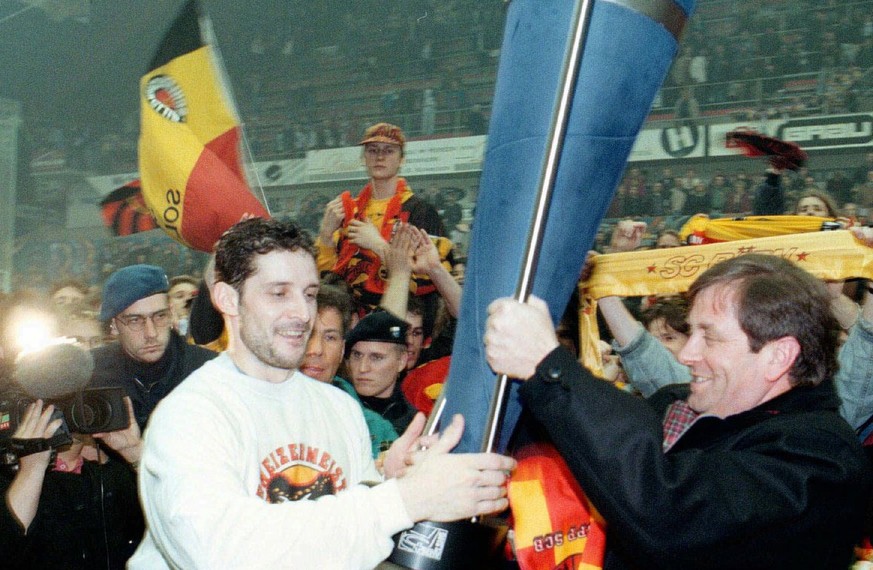 Der Captain des SC Bern, Roberto Triulzi (links) holt sich am Donnerstag 27.3.1997 den Pokal von Praesident Zoelch (rechts) in Zug. (Keystone/Tischler/Limina)