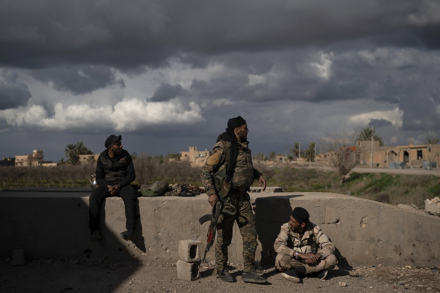 U.S.-backed Syrian Democratic Forces (SDF) fighters stand in an area recently taken by SDF as fight against Islamic State militants continue in the village of Baghouz, Syria, Sunday, Feb. 17, 2019. Is ...