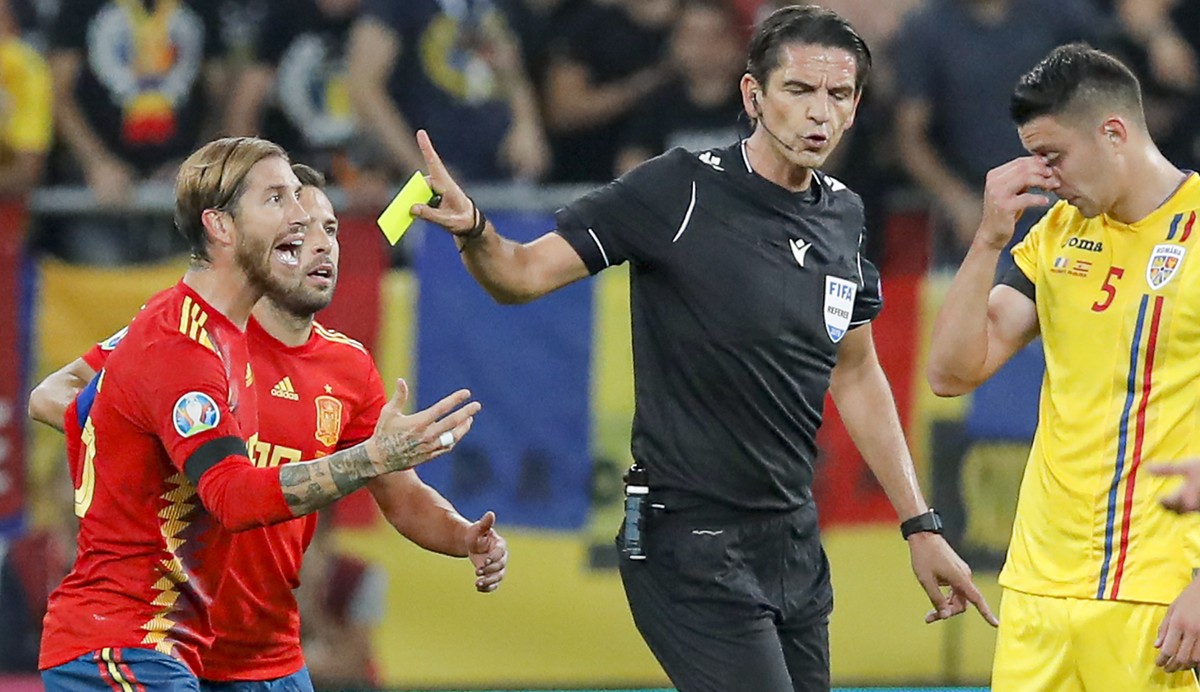 Spain's Sergio Ramos, left reacts after being yellow carded during the Euro 2020 group F qualifying soccer match between Romania and Spain, at the National Arena stadium in Bucharest, Romania, Th ...