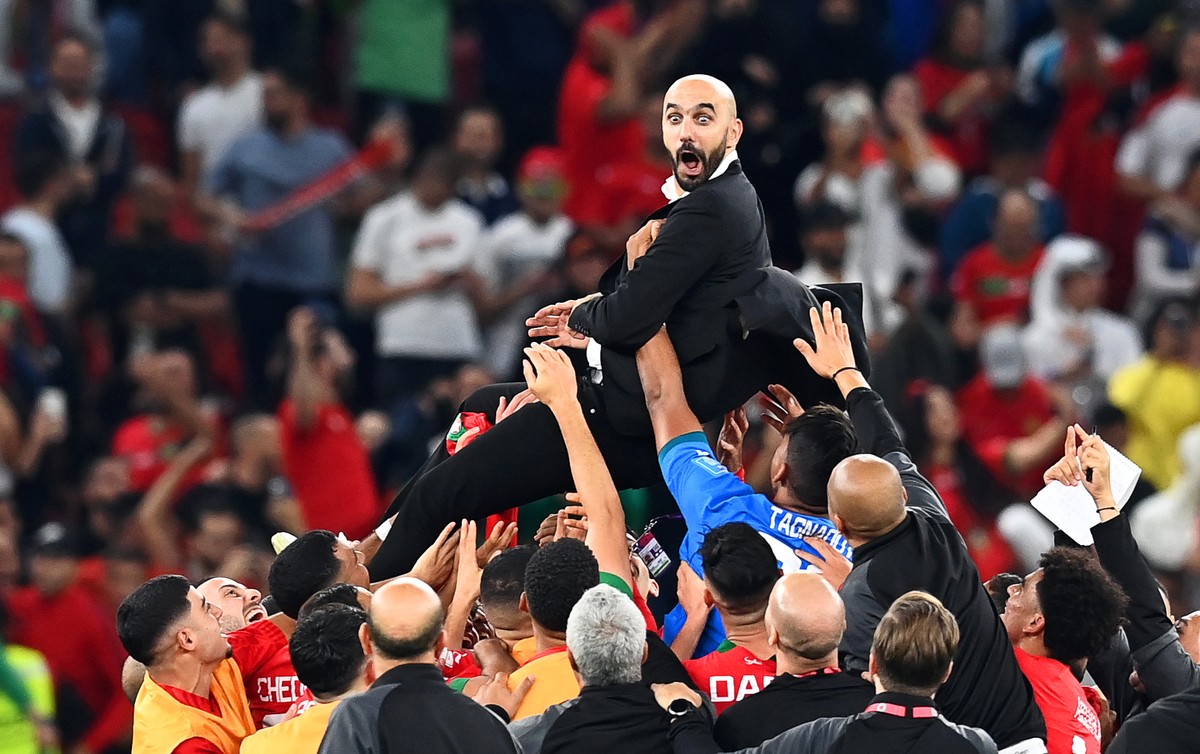 epaselect epa10359700 Morocco's head coach Walid Regragui (up) and his players celebrate after winning the FIFA World Cup 2022 quarter final soccer match between Morocco and Portugal at Al Thumam ...