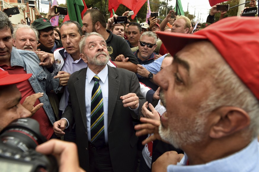 Former Brazilian President Luiz Inacio Lula da Silva, center, is greeted by supporters as he arrives to the Federal Justice building in Curitiba, Brazil, Wednesday, May 10, 2017. Silva is to appear We ...