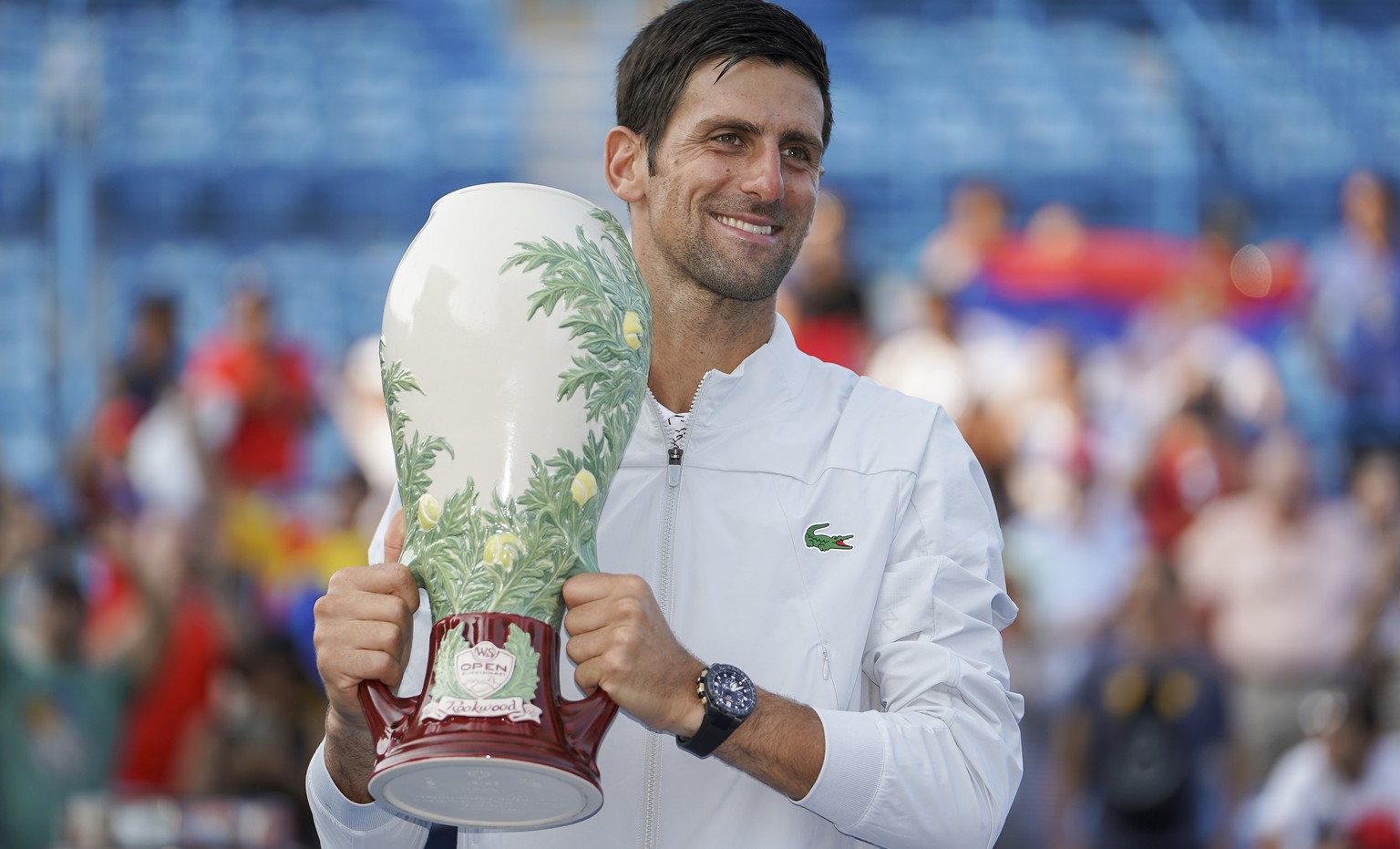 Novak Djokovic, of Serbia, holds the Rookwood Cup after defeating Roger Federer, of Switzerland, during the finals at the Western &amp; Southern Open tennis tournament, Sunday, Aug. 19, 2018, in Mason ...