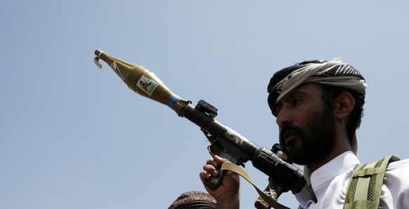 epa08618068 An armed supporter of the Houthi movement carries a RPG-7 rocket-propelled grenade launcher during a protest against the peace agreement to establish diplomatic ties between Israel and the ...